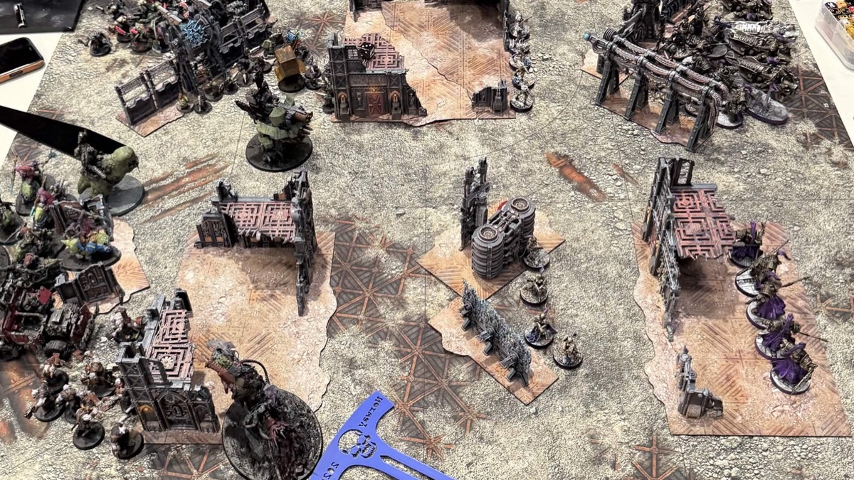 An army deployed across desert terrain on a tournament table
