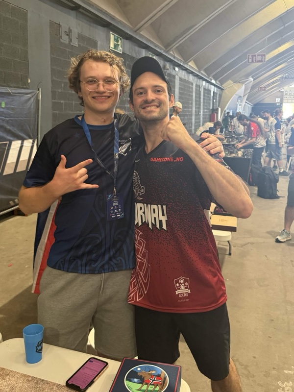 Jonathan Arkin with a teammate in front of the World Team Championships banner